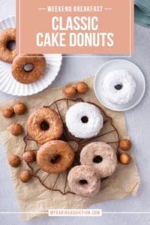 Assorted cake donuts, covered in powdered sugar, cinnamon sugar, and vanilla glaze, arranged on a wire rack. Text overlay includes recipe name.