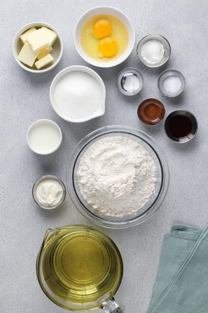 Ingredients for cake donuts arranged on a gray countertop.