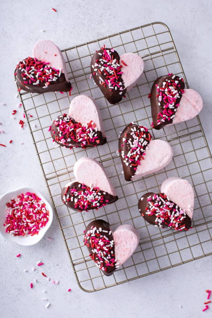 Overhead view of strawberry marshmallows cut into hearts and halfway dipped in chocolate.