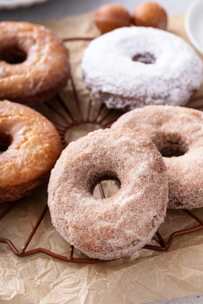 Close up of assorted cake donuts arranged on a wire rack.