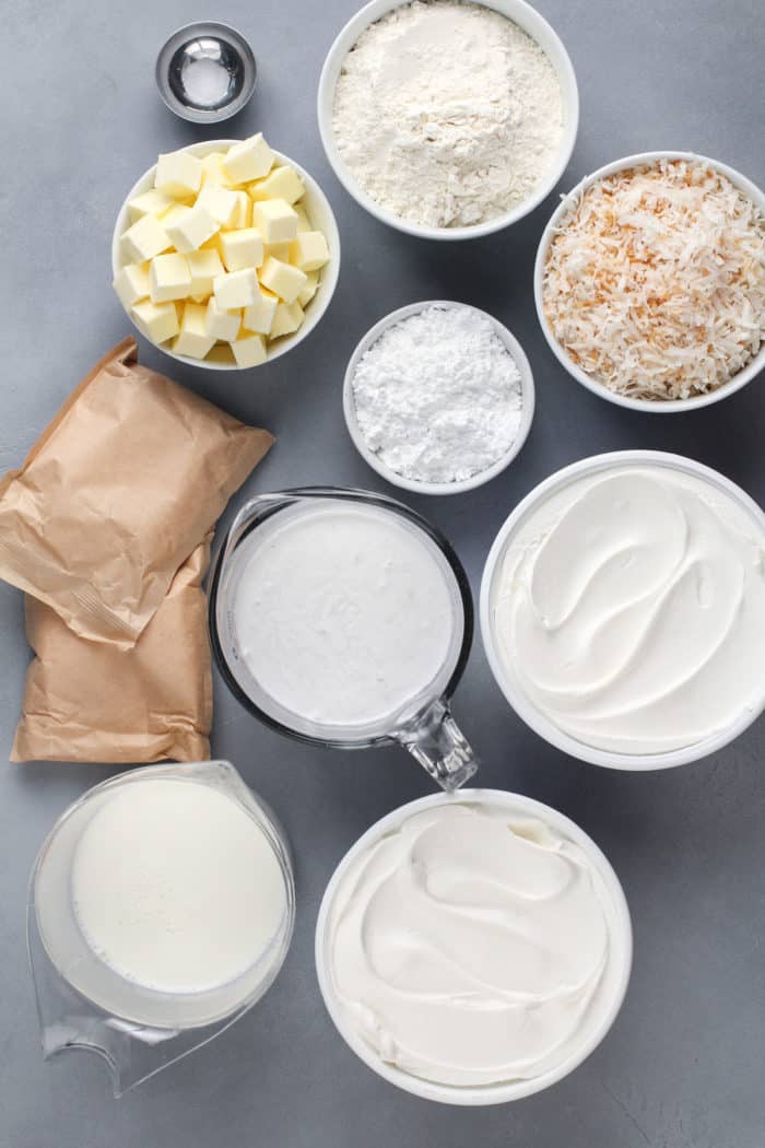 Overhead view of coconut cream bar ingredients arranged on a gray countertop.
