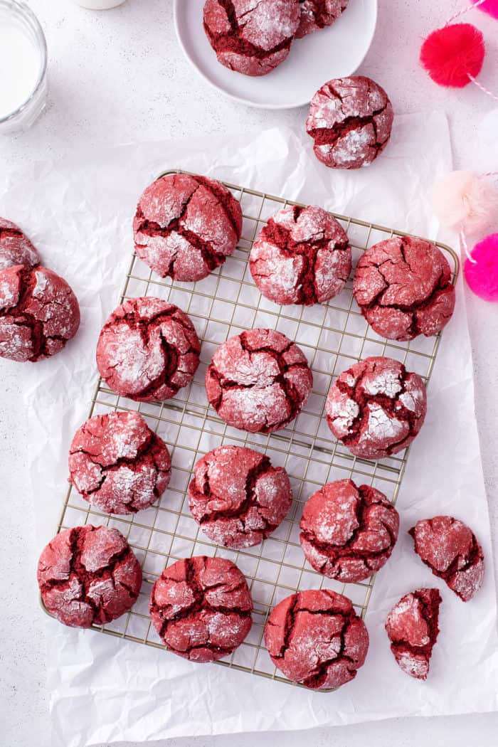 Overhead view of red velvet crinkle cookies cooling on a wire rack.