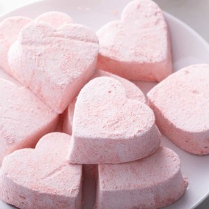 Heart-shaped strawberry marshmallows on a white plate.