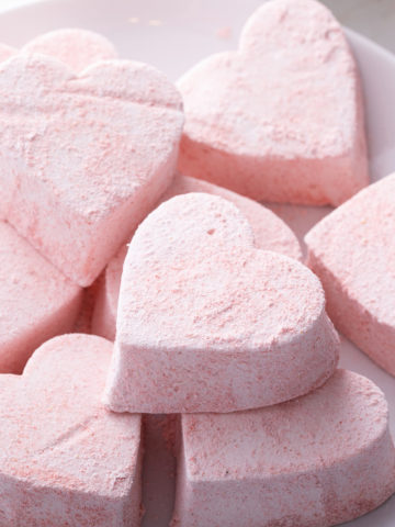 Heart-shaped strawberry marshmallows on a white plate.