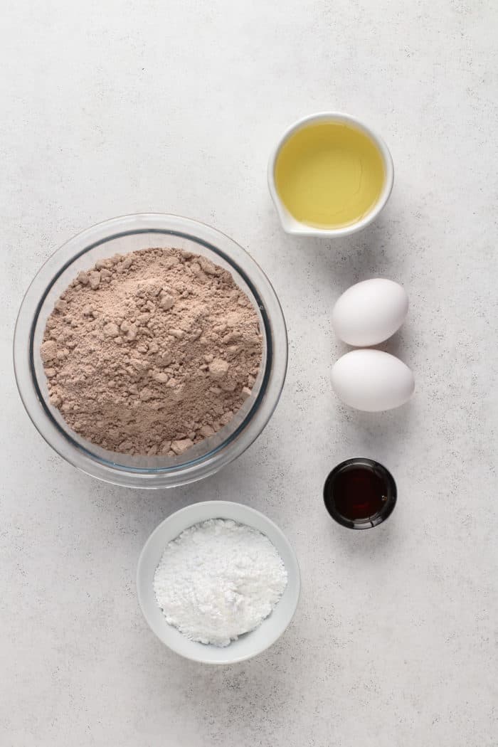 Red velvet crinkle cookies ingredients arranged on a gray countertop.