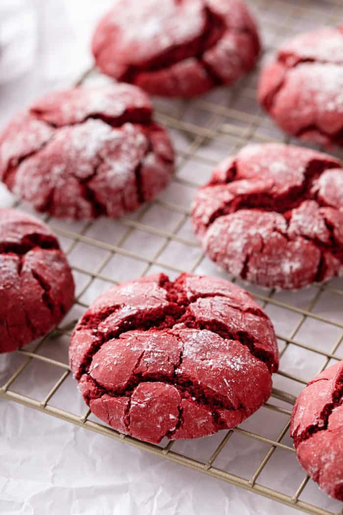 Close up of red velvet crinkle cookies on a wire cooling rack.