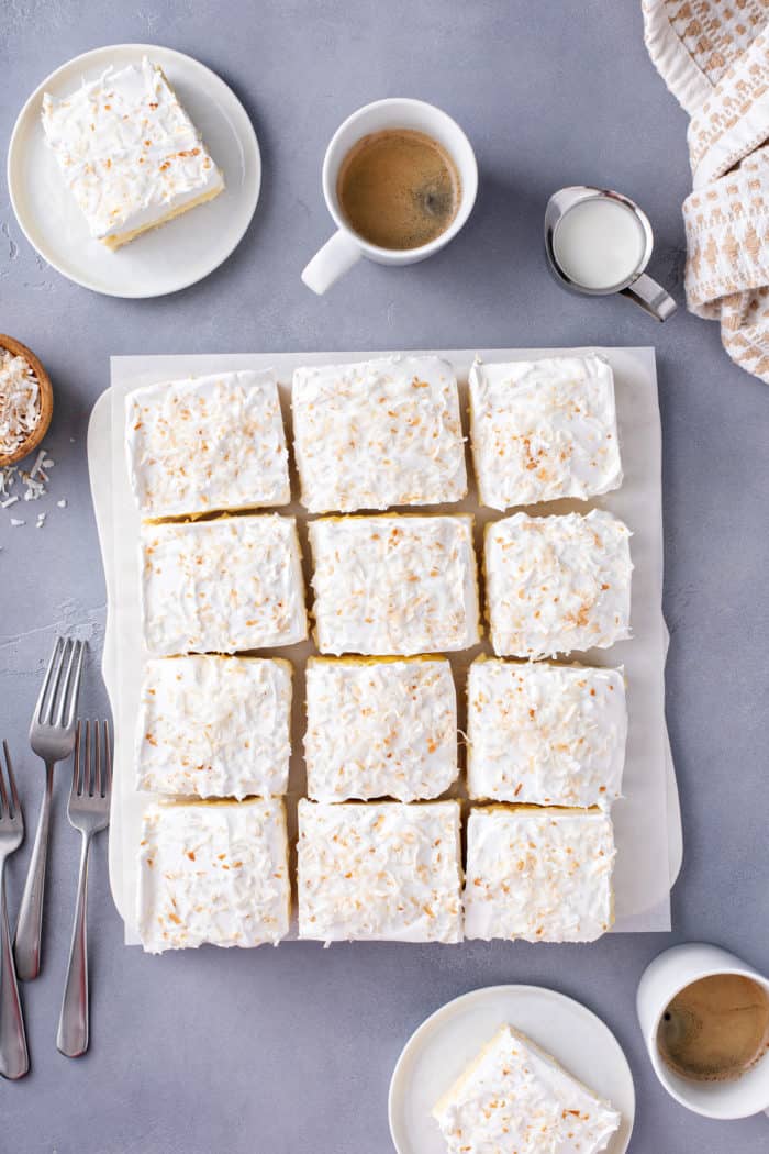 Overhead view of sliced coconut cream bars set on a piece of parchment paper.
