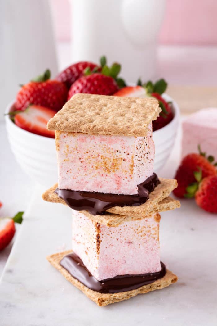 Two s'mores made with strawberry marshmallows stacked on top of each other.