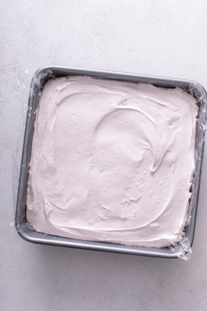 Strawberry marshmallow mixture spread into a metal pan to set.