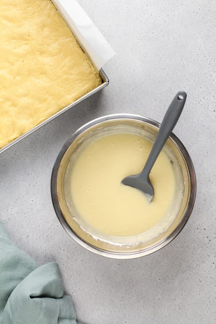 Cream cheese topping for gooey butter cake mixed together in a metal mixing bowl.
