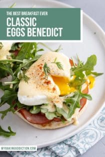 Plated eggs benedict with the egg cut so the yolk is running out over the arugula, candian bacon, and english muffin. Text overlay includes recipe name.