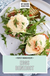 Overhead view of eggs benedict next to a fork and knife on a white plate, set on a blue napkin. Text overlay includes recipe name.