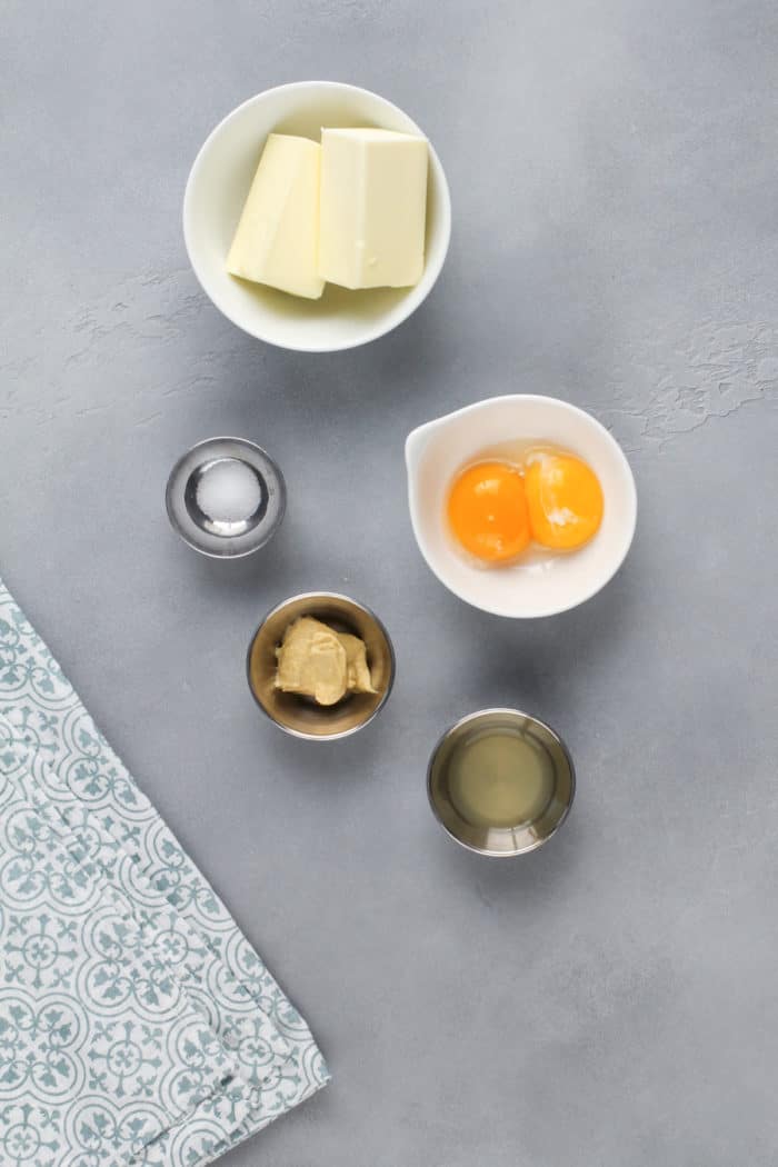 Ingredients for hollandaise sauce on a gray countertop.