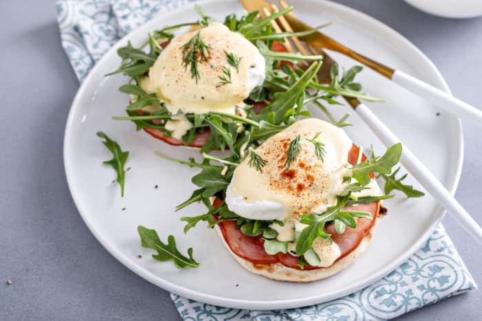 Poached eggs on eggs benedict on a white plate.