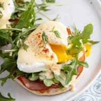 Runny poached egg on eggs benedict.