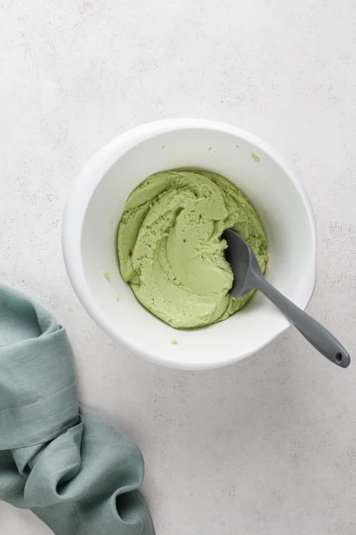 St. Patrick's Day crinkle cookie dough being stirred in a white mixing bowl.