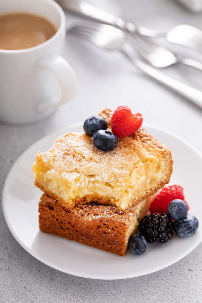 Two pieces of stacked gooey butter cake with a bite taken from the top slice.