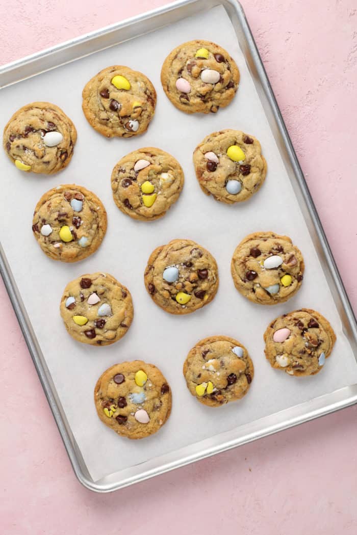 Freshly baked cadbury egg cookies on a parchment-lined baking sheet.