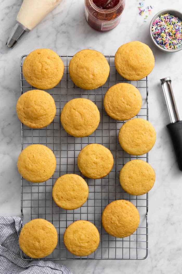 Baked cupcakes cooling on a wire rack.