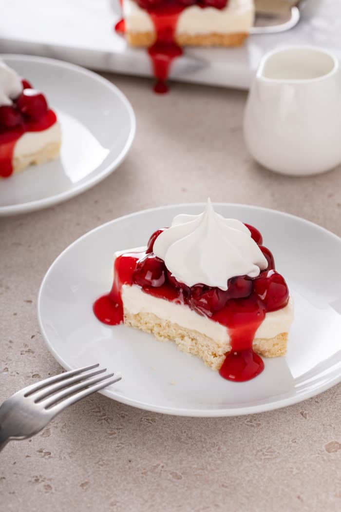 Slice of nana's easy cheesecake on a plate with a bite taken from the corner.