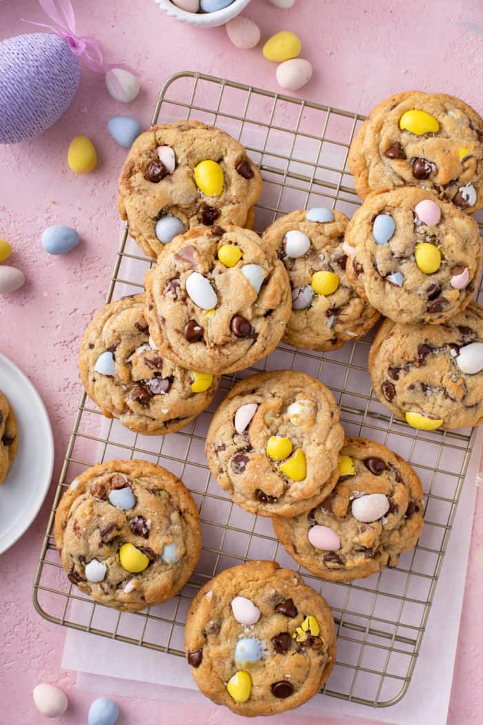 Cadbury egg cookies scattered on a wire cooling rack on top of a piece of parchment paper.