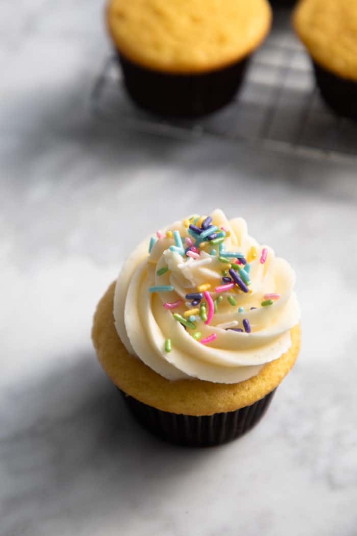 Filled and frosted cupcake set on a countertop.