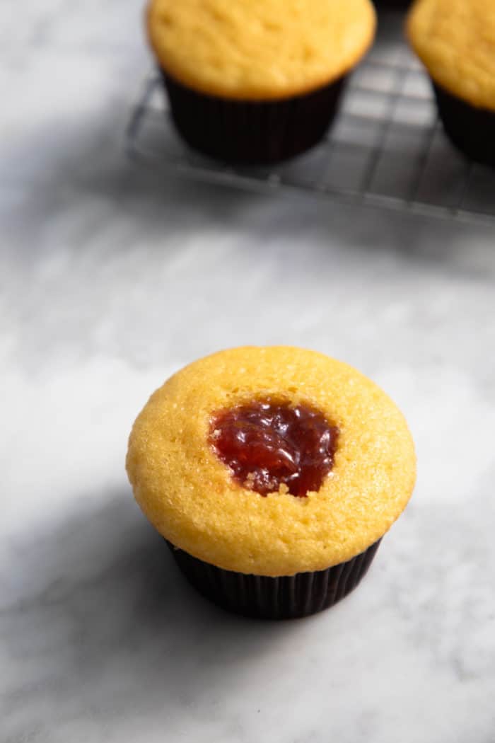 Cupcake that has been cored with a paring knife filled with strawberry jam.