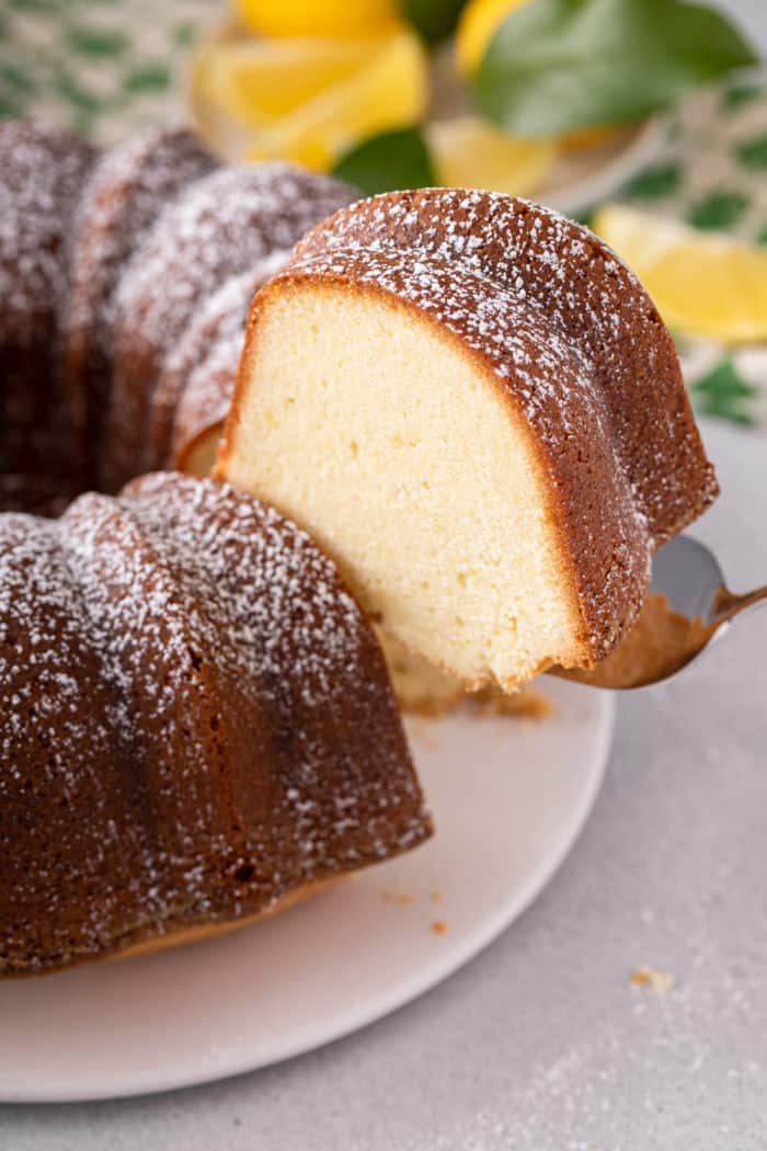 Cake server lifting up a slice of lemon cream cheese found cake.