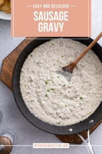 Overhead view of sausage gravy in a black skillet set on a wooden board. Text overlay includes recipe name.