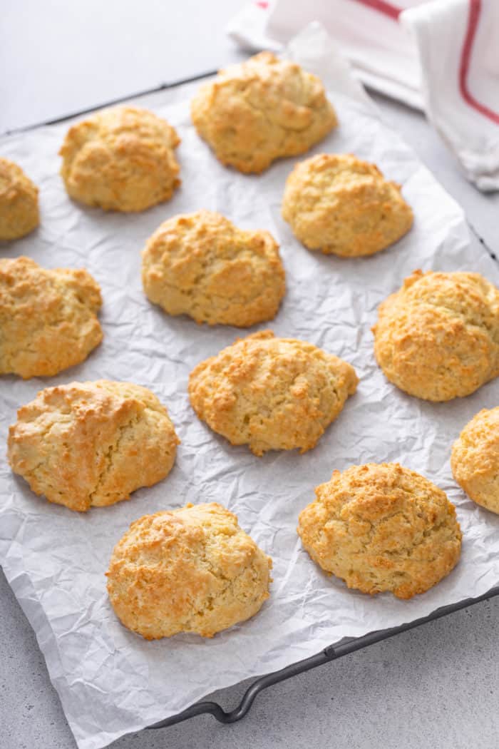 Baked buttermilk drop biscuits on a piece of parchment paper.