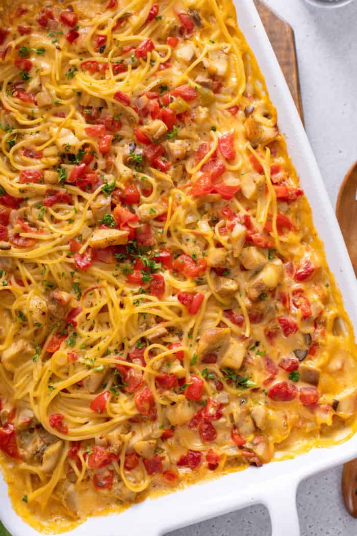 Baked chicken spaghetti in a white casserole dish.