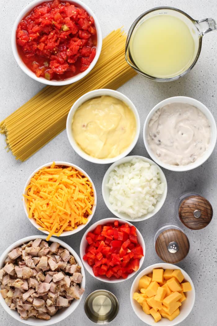 Ingredients for chicken spaghetti arranged on a light-colored countertop.