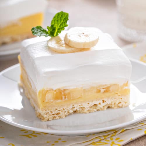Close up of a slice of banana cream bars on a white plate.
