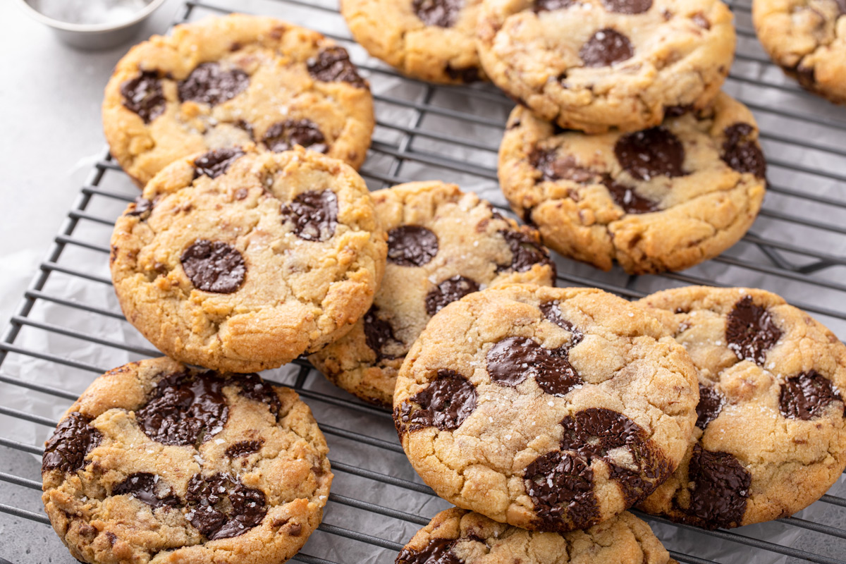 Chocolate chip cookies with brown butter and toffee arranged on a wire cooling rack.