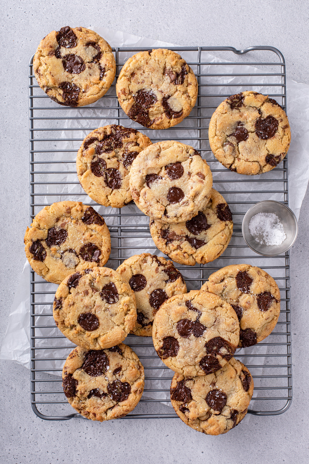 Overhead view of a wire cooling rack filled with chocolate chip cookies with brown butter and toffee.