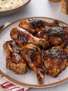 Close up of grilled chicken pieces on a stoneware plate.