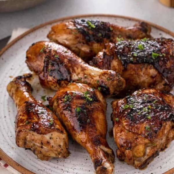 Close up of grilled chicken pieces on a stoneware plate.