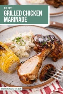 Bite cut from a grilled chicken drumstick on a stoneware plate next to corn and slaw. Text overlay includes recipe name.