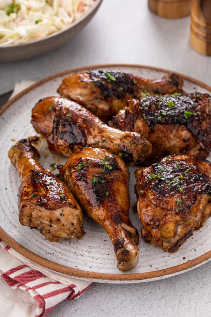 Close up of grilled chicken pieces on a stoneware plate.