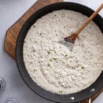 Overhead view of sausage gravy in a black skillet.