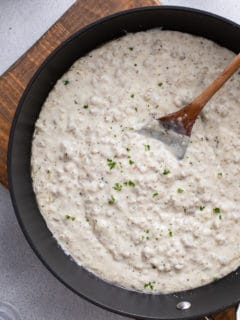 Overhead view of sausage gravy in a black skillet.