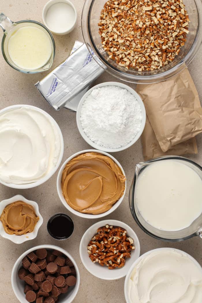 Ingredients for peanut butter pretzel dessert arranged on a countertop.