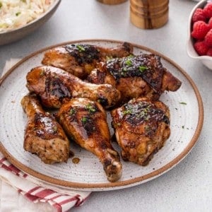 Various cuts of grilled chicken piled onto a stoneware platter.