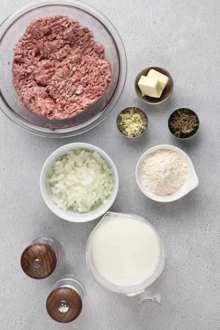 Sausage gravy ingredients arranged on a gray countertop.