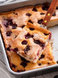Cake server lifting a slice of easy blackberry cobbler out of the pan.