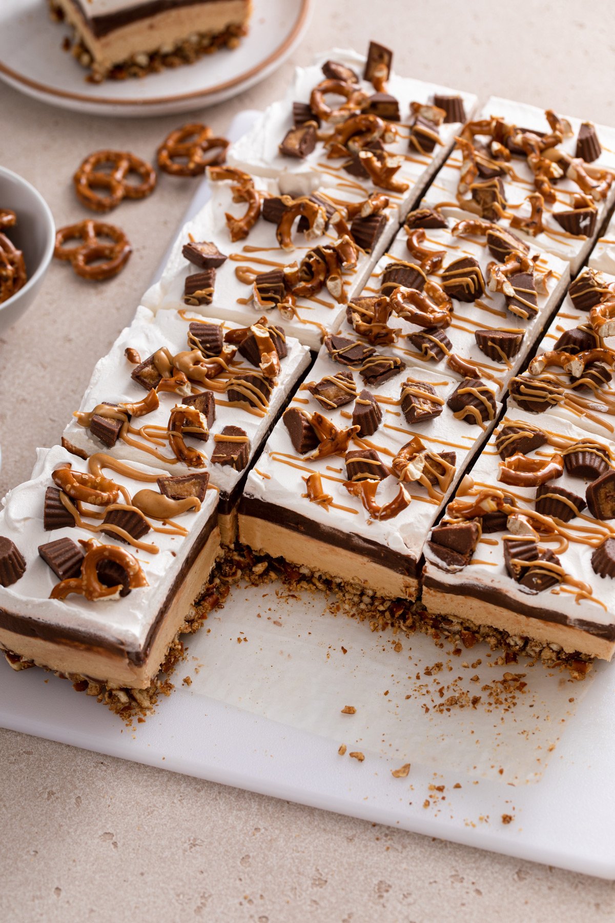 Peanut butter pretzel dessert with two slices removed.
