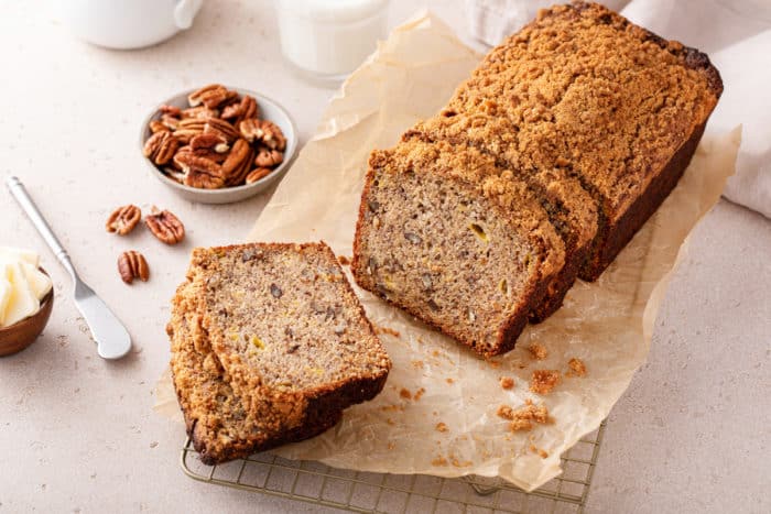 Sliced loaf of banana nut bread on a piece of parchment paper.