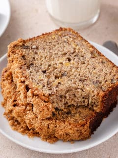 Sliced loaf of banana nut bread on a piece of parchment paper.