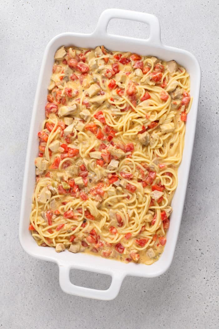 Unbaked chicken spaghetti in a white casserole dish, ready to go in the oven.