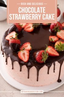 Strawberry-frosted chocolate cake topped with chocolate ganache and fresh strawberries set on a white plate. Text overlay includes recipe name.